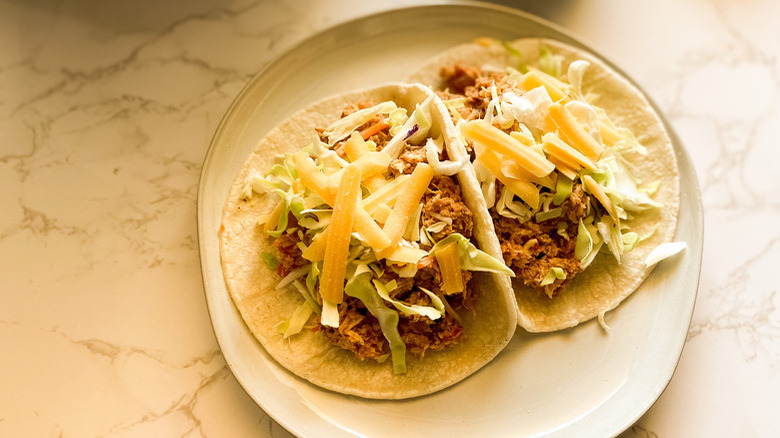 cheese-topped tacos on plate