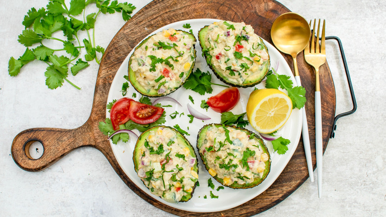 smashed chickpea stuffed avocados on wooden board