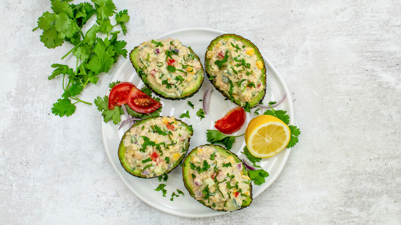 smashed chickpea stuffed avocados on plate