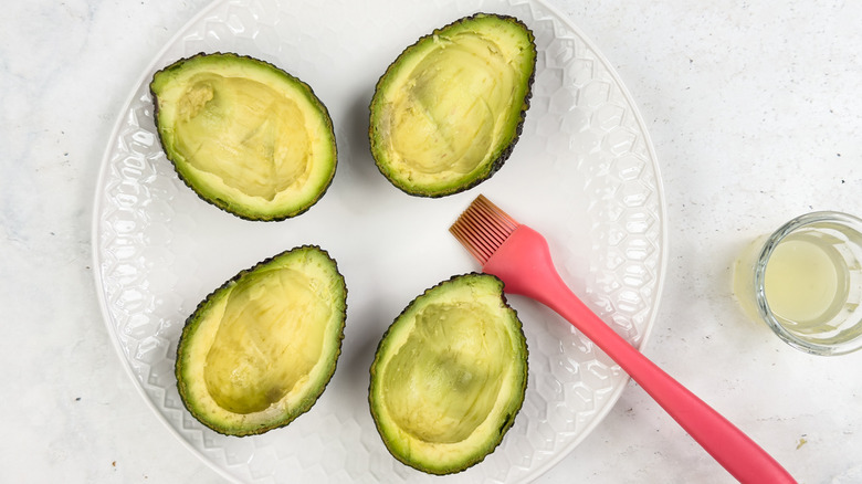 brushing avocados with lemon juice