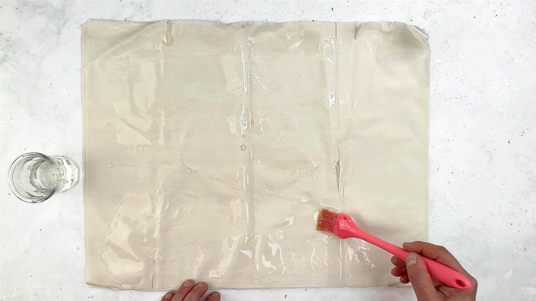 brushing oil on phyllo sheets