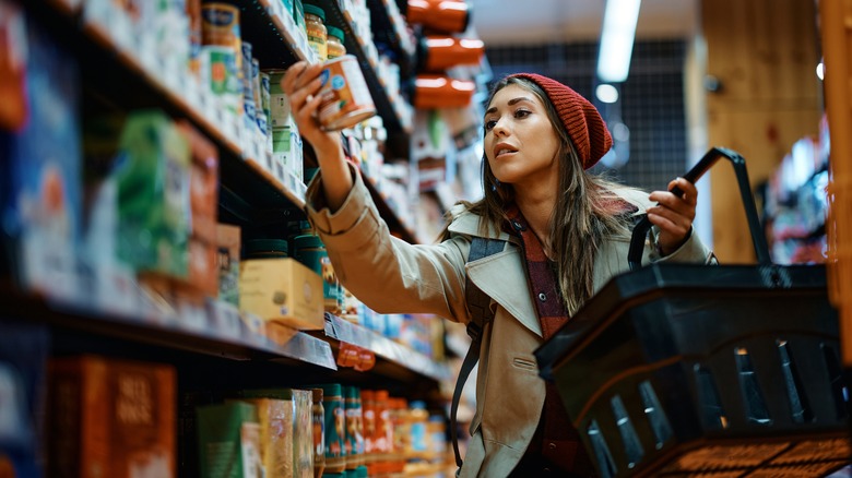 woman picking up canned food