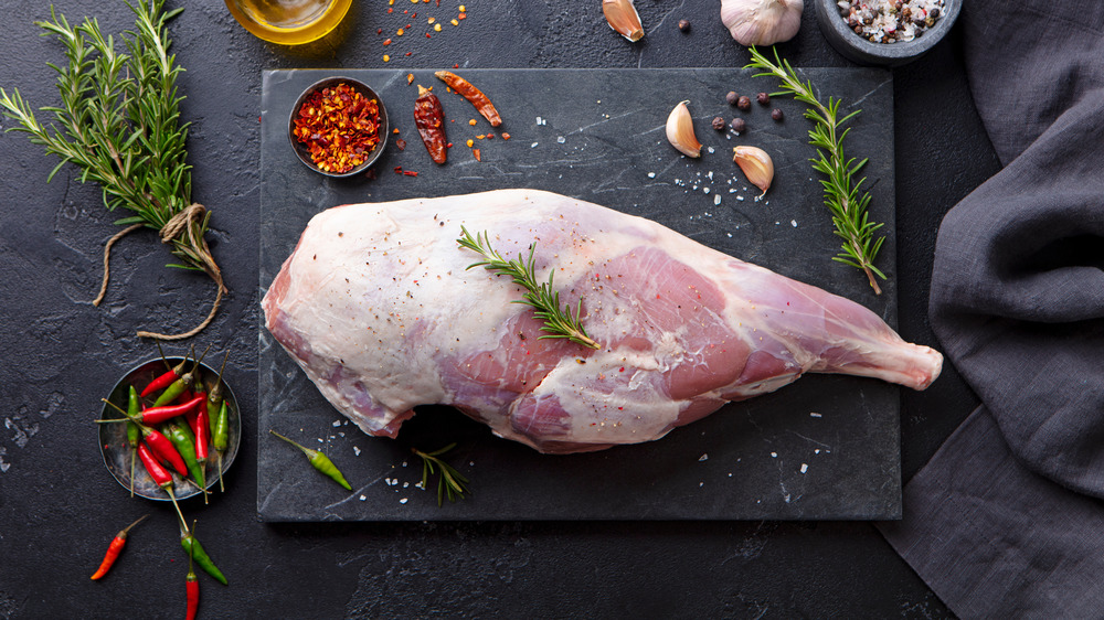 Raw lamb leg with spices and herbs