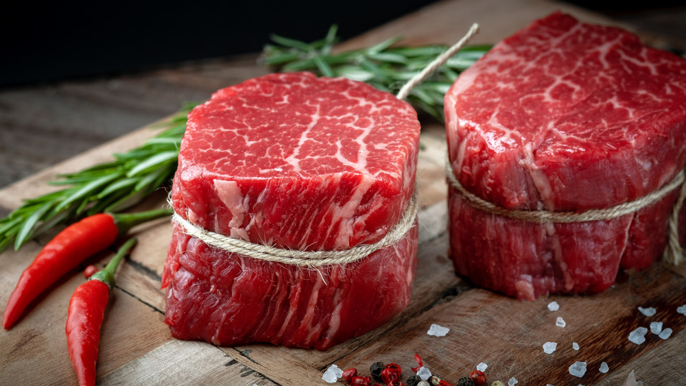 Filet mignon steaks on wooden board