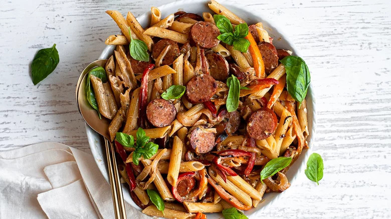 sausage pasta and basil leaves