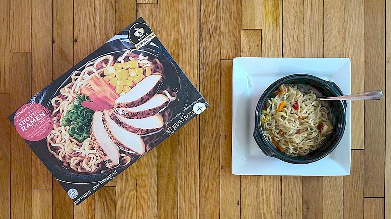 Ajinomoto Tokyo Style Shoyu Ramen with Chicken box and cooked ramen in black bowl with metal spoon