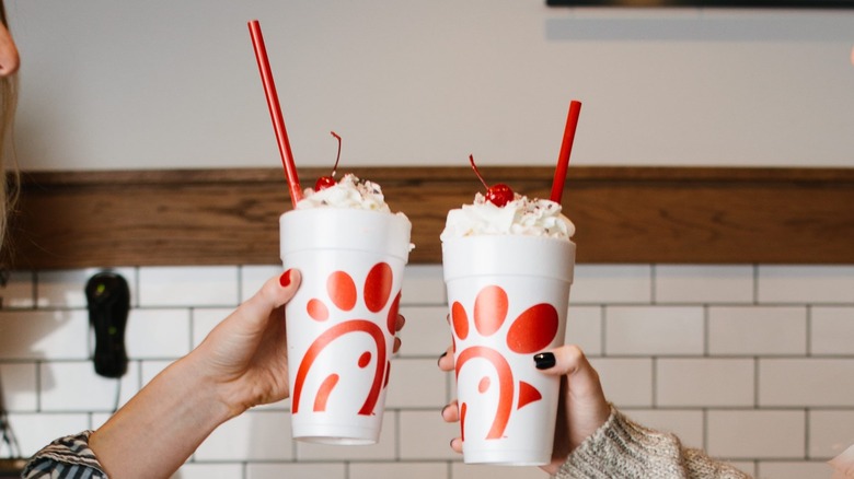 Hands holding two milkshakes