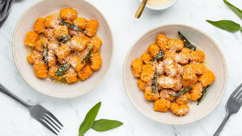 Orange gnocchi in white bowls