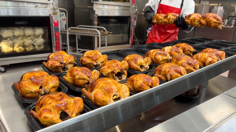 row of rotisserie chickens in tubs