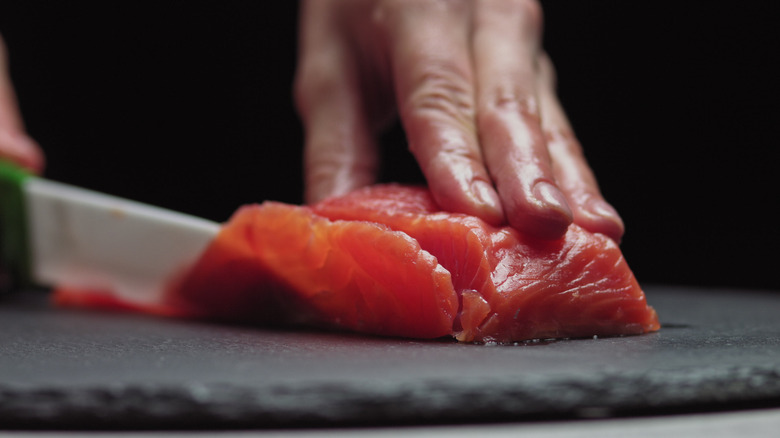 raw salmon being sliced