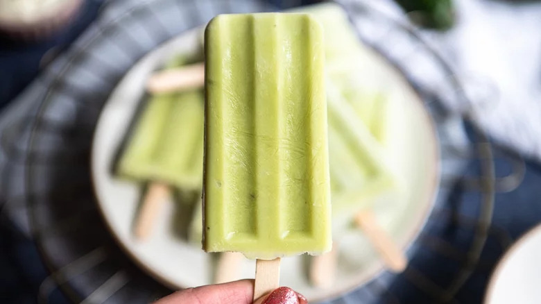 hand holding avocado ice pop