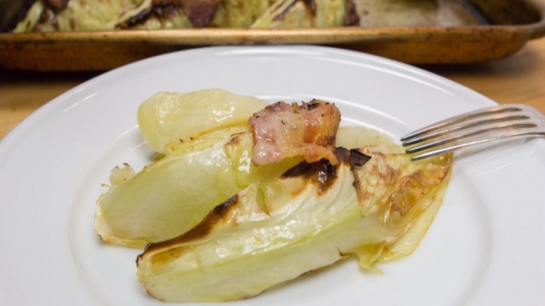 plate of caramelized green cabbage and bacon with fork