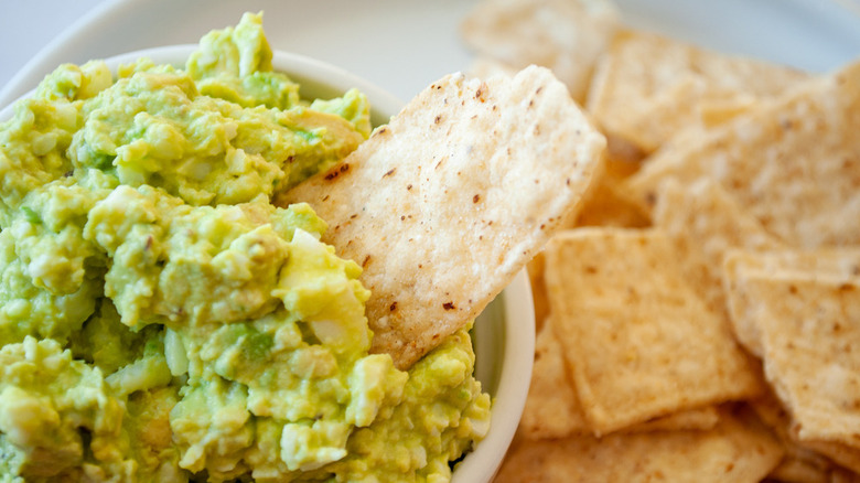 bowl of egg salad with avocado and tortilla chips 