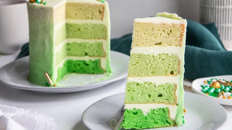 slice of green ombre cake next to whole cake 