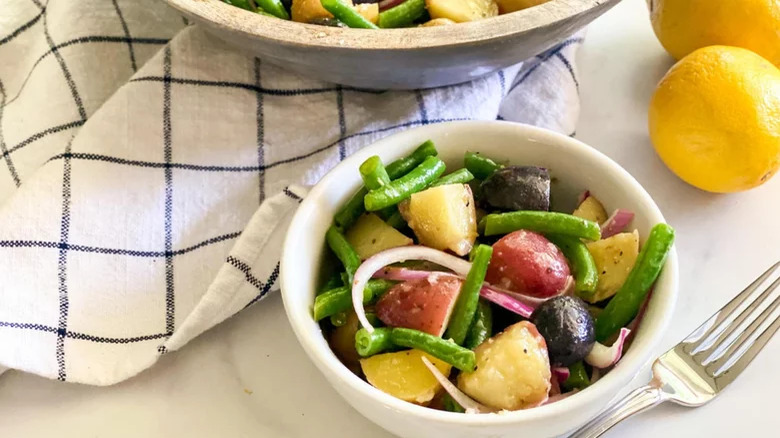 bowl of Old-Fashioned Green Beans and Potatoes with lemon fork dish towel