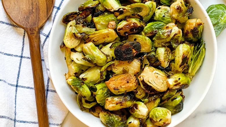 bowl of panfried brussels sprouts with wooden spoon