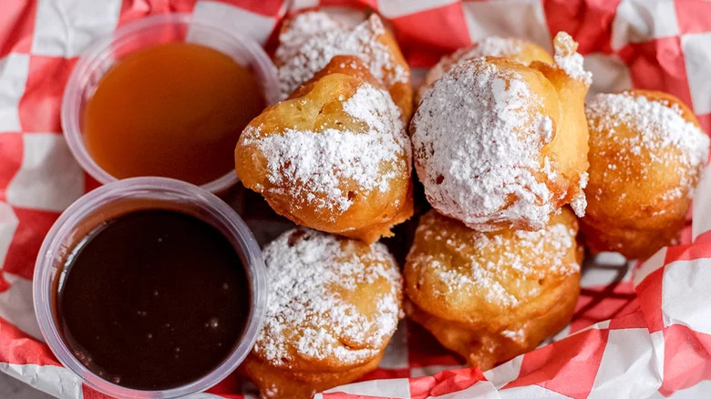 A tray of funnel cake bites with dips