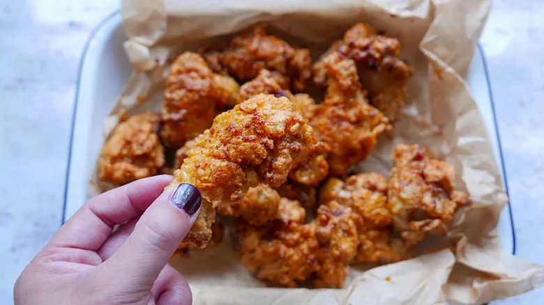 hand holding fried chicken wing