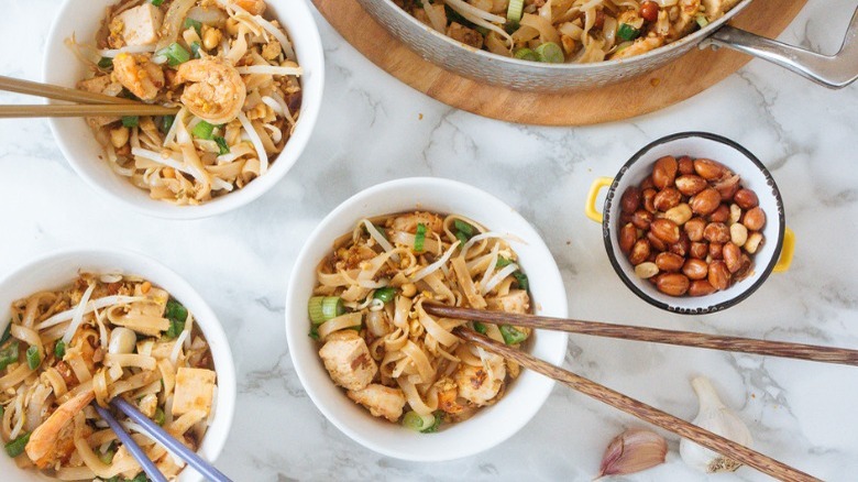 bowls of pad thai with peanuts