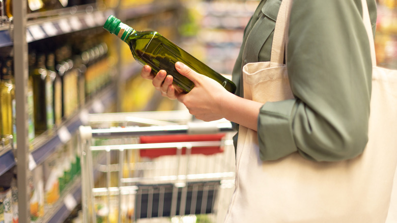 woman holding olive oil bottle