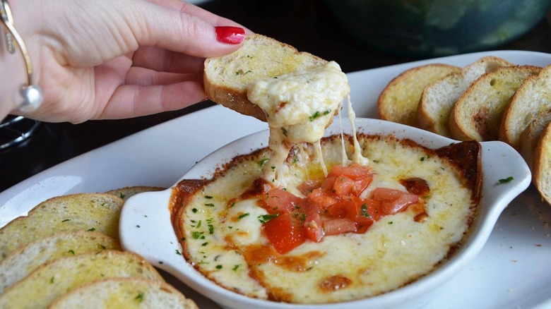 Person eating Smoked Mozzarella Fonduta