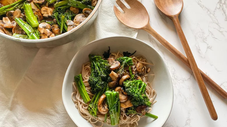 soba noodle bowls with mushrooms and broccolini with wooden utensils