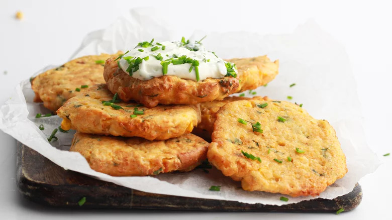 plate of air fryer corn fritters with onion and chive dip on top