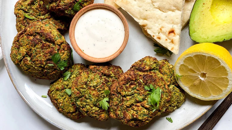 plate of falafel with sauce lemon avocado pita triangles