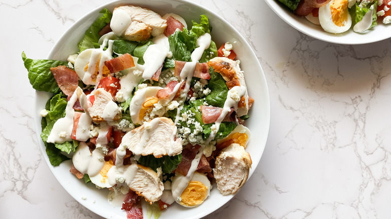 bowls of cobb salad with creamy dressing