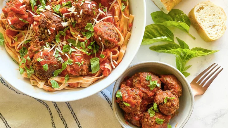 bowls of lentil meatballs with pasta and bread