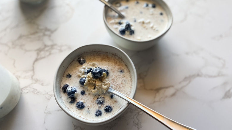 bowls of overnight oats with blueberries and spoons