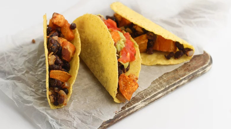 roasted sweet potato and black bean tacos on wooden board