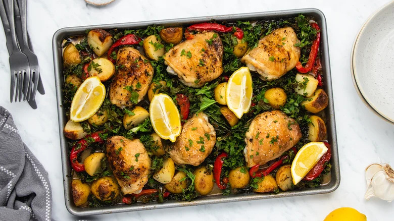 sheet pan chicken and kale with garlic knives and forks