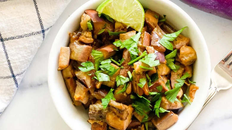 bowl of spicy chinese eggplant with lime and fork