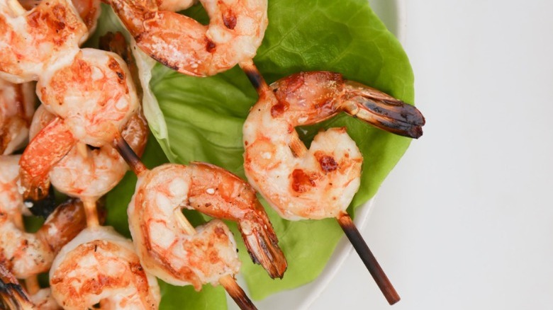 skewers of grilled shrimp on lettuce