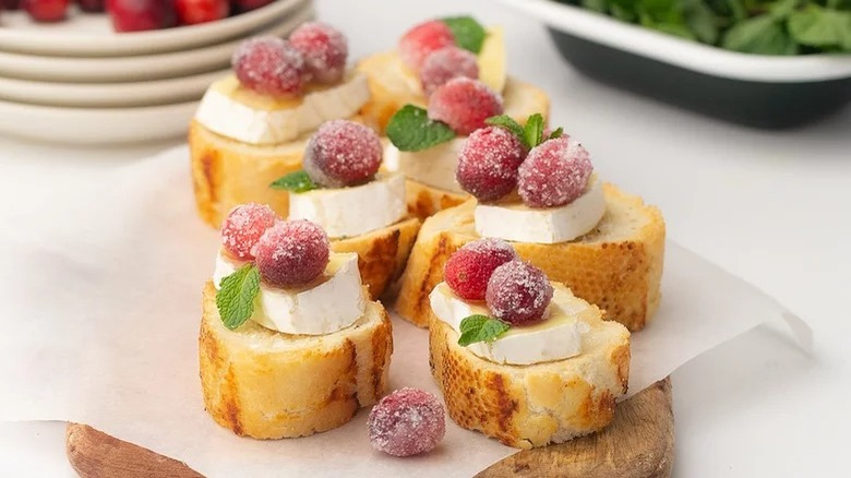 wooden board with cranberry brie bites