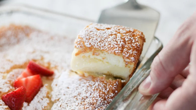 A slice of cake being lifted from a baking pan