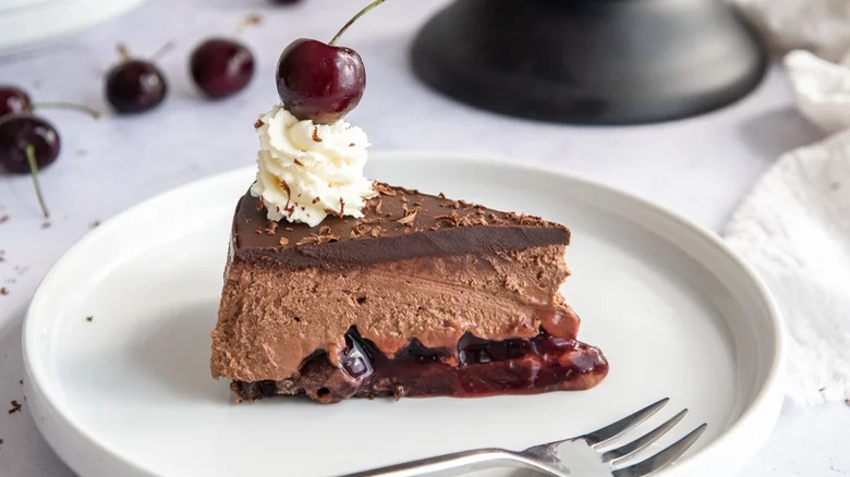 A slice of black forest cheesecake in a plate