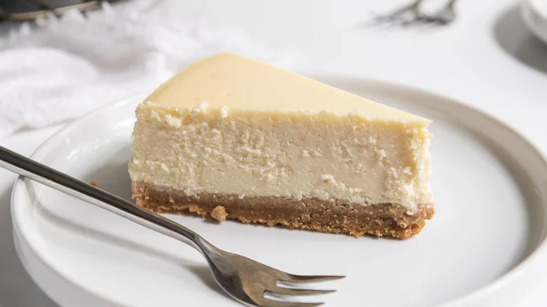 A slice of cheesecake on a plate with a fork