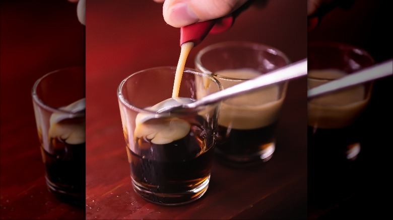 Bartender using bar spoon technique to make shot