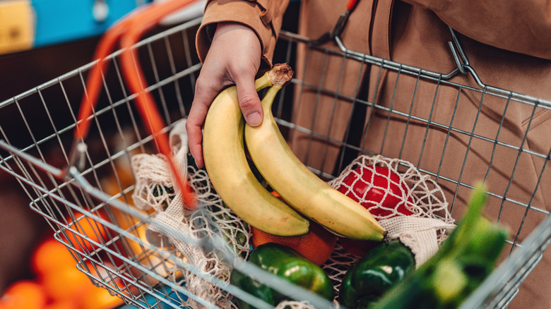 Putting bananas in grocery basket