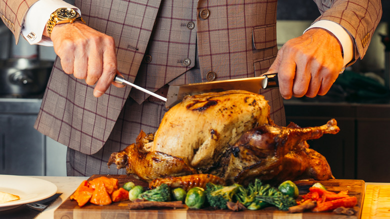 hands carving a turkey