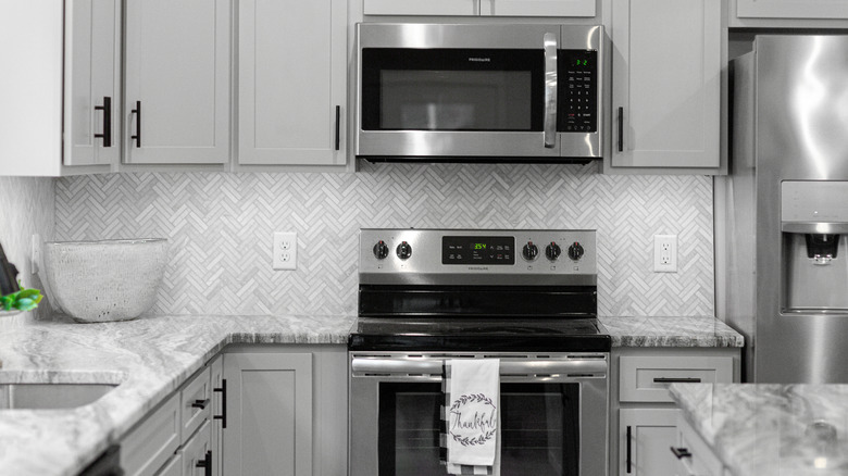 home kitchen with clean microwave, oven, stovetop, and refrigerator