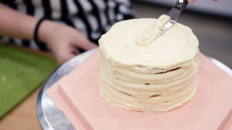 Person frosting a cake