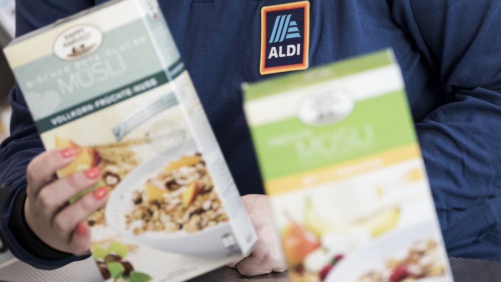 Aldi employee holding products