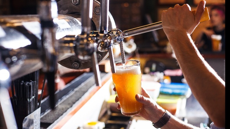 Person pouring beer from a tap