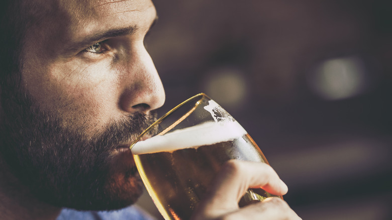 concerned looking man drinking beer