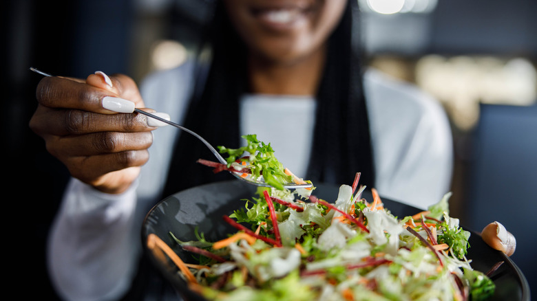 smiling person holding a salad