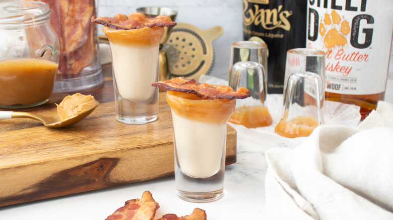 cream drinks in caramel-rimmed glasses garnished with bacon strips