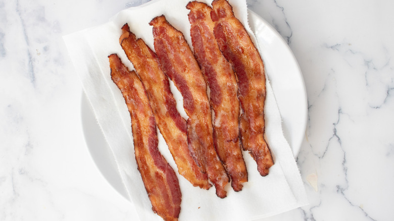 cooked bacon strips on a paper towel-lined plate